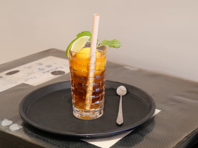 Стакан чая со льдом, украшенный мятой и лимоном